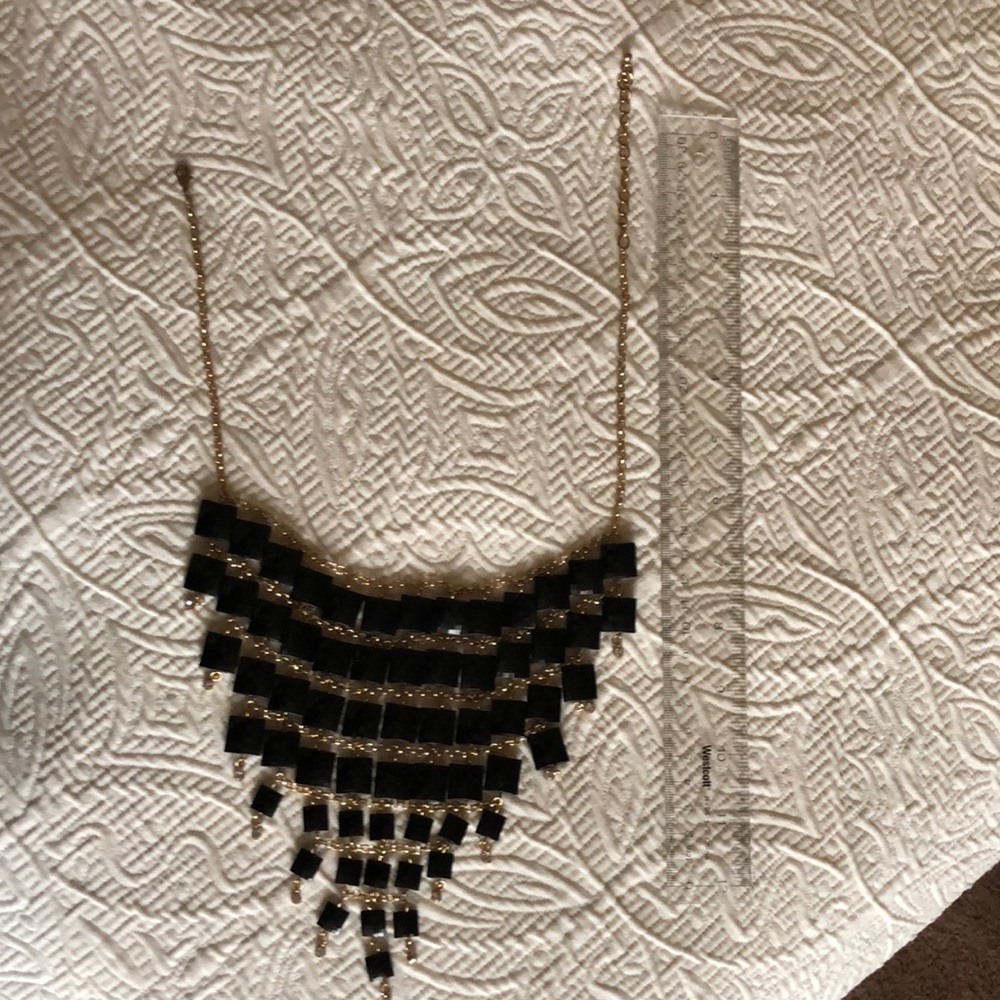 Costume jewelry necklace.  Gold chain with black and rhinestone details.